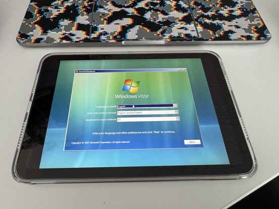 iPad Mini displaying the Windows Vista installation screen with language, time, and keyboard settings.